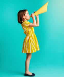 Girl In Yellow Dress With Paper Megaphone On Blue Background by Jacob Lund Photography from NounProject.com